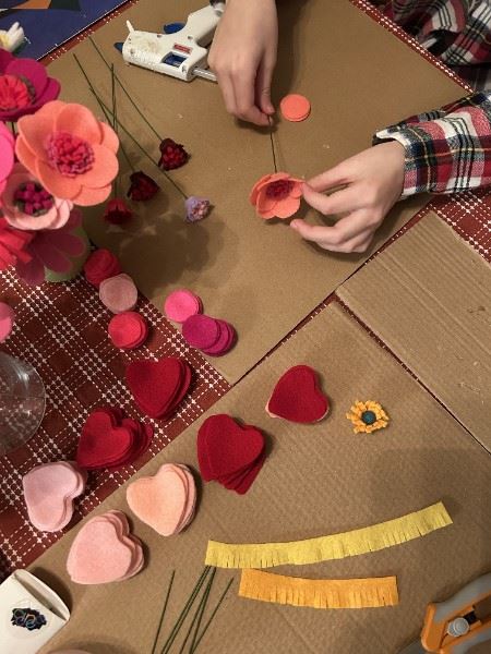 Looking down on Josie's hands crafting felt flowers